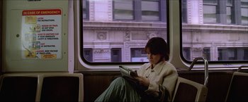 Movie still from “The Lake House” (2006), directed by Alejandro Agresti – A woman sitting on a train reading a newspaper; Medium shot, Over the shoulder angle
