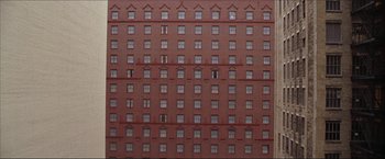 Movie still from “The Lake House” (2006), directed by Alejandro Agresti – A brick building has many windows on each side; Extreme Wide shot, Overhead angle