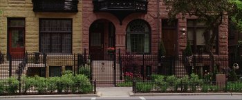 Movie still from “The Lake House” (2006), directed by Alejandro Agresti – A brick building with a wrought iron fence and gate; Extreme Wide shot, High angle