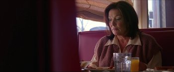 Movie still from “The Lake House” (2006), directed by Alejandro Agresti – A woman sitting at a table with a plate in front of her; Close Up shot, Low angle