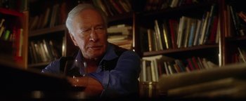 Movie still from “The Lake House” (2006), directed by Alejandro Agresti – An older man sitting at a table holding a wine glass; Close Up shot, Over the shoulder angle