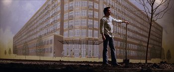 Movie still from “The Lake House” (2006), directed by Alejandro Agresti – A man standing in front of a painting of a building; Wide shot, Low angle