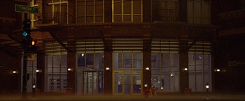 Movie still from “The Lake House” (2006), directed by Alejandro Agresti – Two people sitting on the ground in front of a building at night; Extreme Wide shot, Low angle
