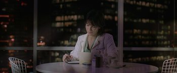 Movie still from “The Lake House” (2006), directed by Alejandro Agresti – A woman sitting at a table with a cup of coffee; Medium shot, Over the shoulder angle
