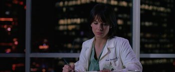 Movie still from “The Lake House” (2006), directed by Alejandro Agresti – A woman in a white lab coat writing on a piece of paper; Close Up shot, Over the shoulder angle