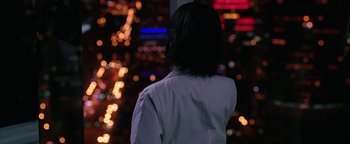 Movie still from “The Lake House” (2006), directed by Alejandro Agresti – A woman standing in front of a city at night; Medium shot, Over the shoulder angle