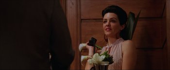 Movie still from “The Lake House” (2006), directed by Alejandro Agresti – A woman holding a phone and a vase of flowers; Close Up shot, Over the shoulder angle