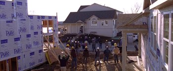 Movie still from “The Lake House” (2006), directed by Alejandro Agresti – A group of construction workers standing in front of a house; Extreme Wide shot, High angle