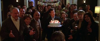 Movie still from “The Lake House” (2006), directed by Alejandro Agresti – A group of people standing around a cake with lit candles on it; Medium shot, High angle