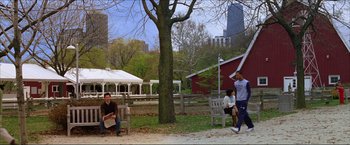 Movie still from “The Lake House” (2006), directed by Alejandro Agresti – A group of people sitting on park benches near trees; Wide shot, Over the shoulder angle