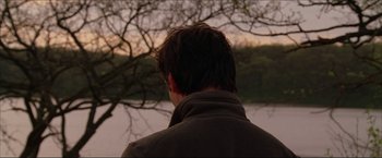 Movie still from “The Lake House” (2006), directed by Alejandro Agresti – A man standing in front of a body of water; Close Up shot, Over the shoulder angle