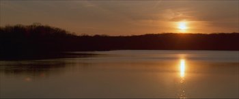Movie still from “The Lake House” (2006), directed by Alejandro Agresti – A body of water at sunset with trees in the background; Extreme Wide shot, Low angle