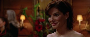 Movie still from “The Lake House” (2006), directed by Alejandro Agresti – A beautiful woman with short brown hair smiling; Close Up shot, Over the shoulder angle