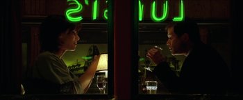 Movie still from “The Lake House” (2006), directed by Alejandro Agresti – Two people sitting at a table in front of a neon sign; Medium shot, Over the shoulder angle