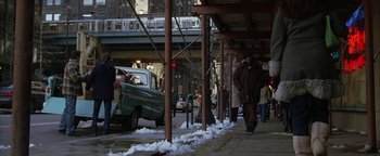 Movie still from “The Lake House” (2006), directed by Alejandro Agresti – A man walking down a sidewalk next to a green truck; Wide shot, High angle
