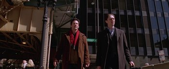 Movie still from “The Lake House” (2006), directed by Alejandro Agresti – A couple of men standing next to each other on the street; Medium shot, Low angle