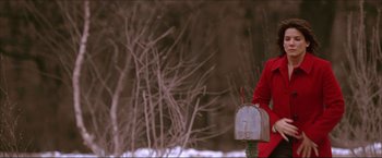 Movie still from “The Lake House” (2006), directed by Alejandro Agresti – A person in a red jacket sitting in front of a mailbox; Medium shot, Low angle