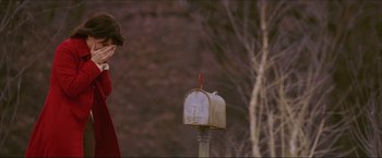 Movie still from “The Lake House” (2006), directed by Alejandro Agresti – A person standing next to a mailbox on a post; Medium shot, Over the shoulder angle