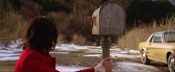 Movie still from “The Lake House” (2006), directed by Alejandro Agresti – A woman in a red coat looking at an old mailbox; Close Up shot, Low angle