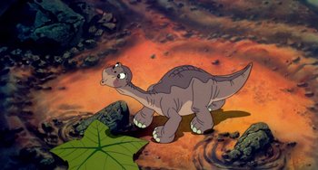 Movie still from “The Land Before Time” (1988), directed by Don Bluth – A dinosaur is standing in the middle of a field; Wide shot, High angle