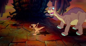 Movie still from “The Land Before Time” (1988), directed by Don Bluth – A dinosaur and a baby dinosaur in a cave; Wide shot, High angle