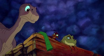 Movie still from “The Land Before Time” (1988), directed by Don Bluth – A group of animals sitting next to each other on top of a pile of wood; Wide shot, Low angle
