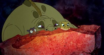 Movie still from “The Land Before Time” (1988), directed by Don Bluth – A group of cartoon characters sitting next to each other on a rock; Wide shot, High angle