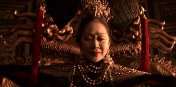 Movie still from “The Last Emperor” (1987), directed by Bernardo Bertolucci – An older woman wearing a crown and a necklace; Close Up shot, Low angle