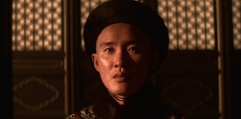 Movie still from “The Last Emperor” (1987), directed by Bernardo Bertolucci – A man wearing a hat is looking at the camera; Close Up shot, Low angle