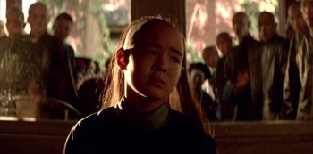 Movie still from “The Last Emperor” (1987), directed by Bernardo Bertolucci – A young person with long hair is looking at the camera; Close Up shot, Over the shoulder angle