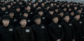 Movie still from “The Last Emperor” (1987), directed by Bernardo Bertolucci – A group of men in black jackets and hats; Wide shot, High angle