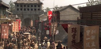 Movie still from “The Last Emperor” (1987), directed by Bernardo Bertolucci – A group of people walking down a street; Extreme Wide shot, High angle