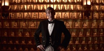 Movie still from “The Last Emperor” (1987), directed by Bernardo Bertolucci – A man in a tuxedo standing in front of a wall; Medium shot, Low angle