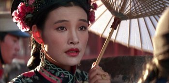 Movie still from “The Last Emperor” (1987), directed by Bernardo Bertolucci – A woman in traditional chinese clothing holding an umbrella; Close Up shot, Low angle