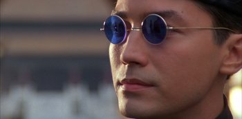 Movie still from “The Last Emperor” (1987), directed by Bernardo Bertolucci – A person wearing round glasses; Close Up shot, Low angle