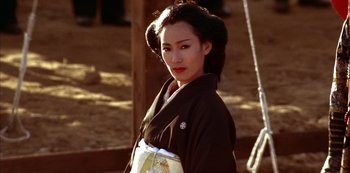 Movie still from “The Last Emperor” (1987), directed by Bernardo Bertolucci – A woman in a black kimono is posing for a picture; Close Up shot, Low angle