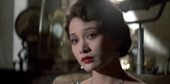 Movie still from “The Last Emperor” (1987), directed by Bernardo Bertolucci – A woman with red lipstick looking at the camera; Close Up shot, Over the shoulder angle