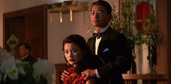 Movie still from “The Last Emperor” (1987), directed by Bernardo Bertolucci – A man and a woman dressed in formal wear; Medium shot, Low angle