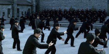 Movie still from “The Last Emperor” (1987), directed by Bernardo Bertolucci – A group of men in black suits and black hats; Wide shot, High angle