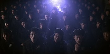 Movie still from “The Last Emperor” (1987), directed by Bernardo Bertolucci – A group of people in black hats and black jackets; Wide shot, High angle