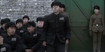 Movie still from “The Last Emperor” (1987), directed by Bernardo Bertolucci – A group of men in black suits and hats; Medium shot, Low angle