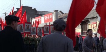Movie still from “The Last Emperor” (1987), directed by Bernardo Bertolucci – A crowd of people are holding up red flags; Extreme Wide shot, Over the shoulder angle