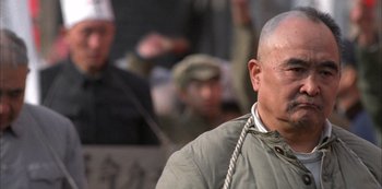 Movie still from “The Last Emperor” (1987), directed by Bernardo Bertolucci – An older man with a shaved head is looking to his left; Close Up shot, Low angle