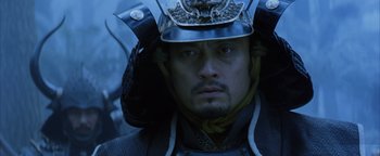 Movie still from “The Last Samurai” (2003), directed by Edward Zwick – A person wearing a helmet and holding an umbrella; Close Up shot, Low angle