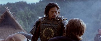 Movie still from “The Last Samurai” (2003), directed by Edward Zwick – A man in a leather armor is standing next to another man; Close Up shot, Over the shoulder angle