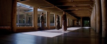 Movie still from “The Last Samurai” (2003), directed by Edward Zwick – A group of people standing in a room with pillars; Extreme Wide shot, Low angle