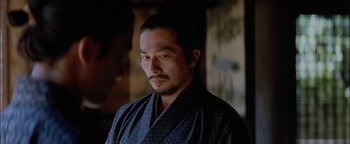 Movie still from “The Last Samurai” (2003), directed by Edward Zwick – A man in a black robe looking to his left; Close Up shot, Over the shoulder angle