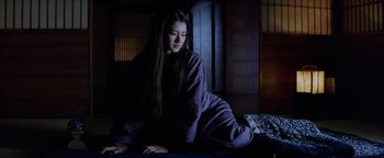 Movie still from “The Last Samurai” (2003), directed by Edward Zwick – A young woman sitting on a bed in the dark; Medium shot, Low angle