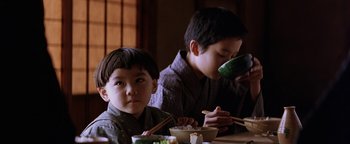Movie still from “The Last Samurai” (2003), directed by Edward Zwick – Two young boys sitting at a table eating food; Close Up shot, High angle