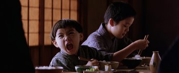 Movie still from “The Last Samurai” (2003), directed by Edward Zwick – Two young boys sitting at a table with food; Close Up shot, Low angle